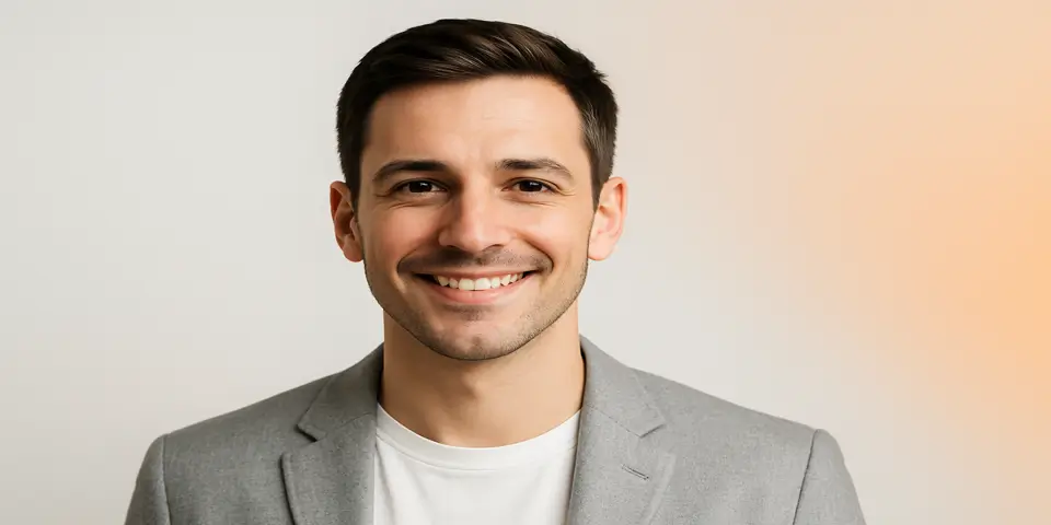 Young marketing professional in gray blazer smiling confidently.